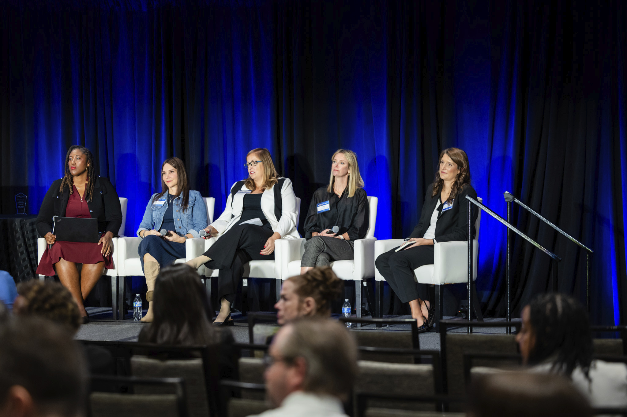 Brianna Lombardi sitting on stage with 3 other panelists and a moderator