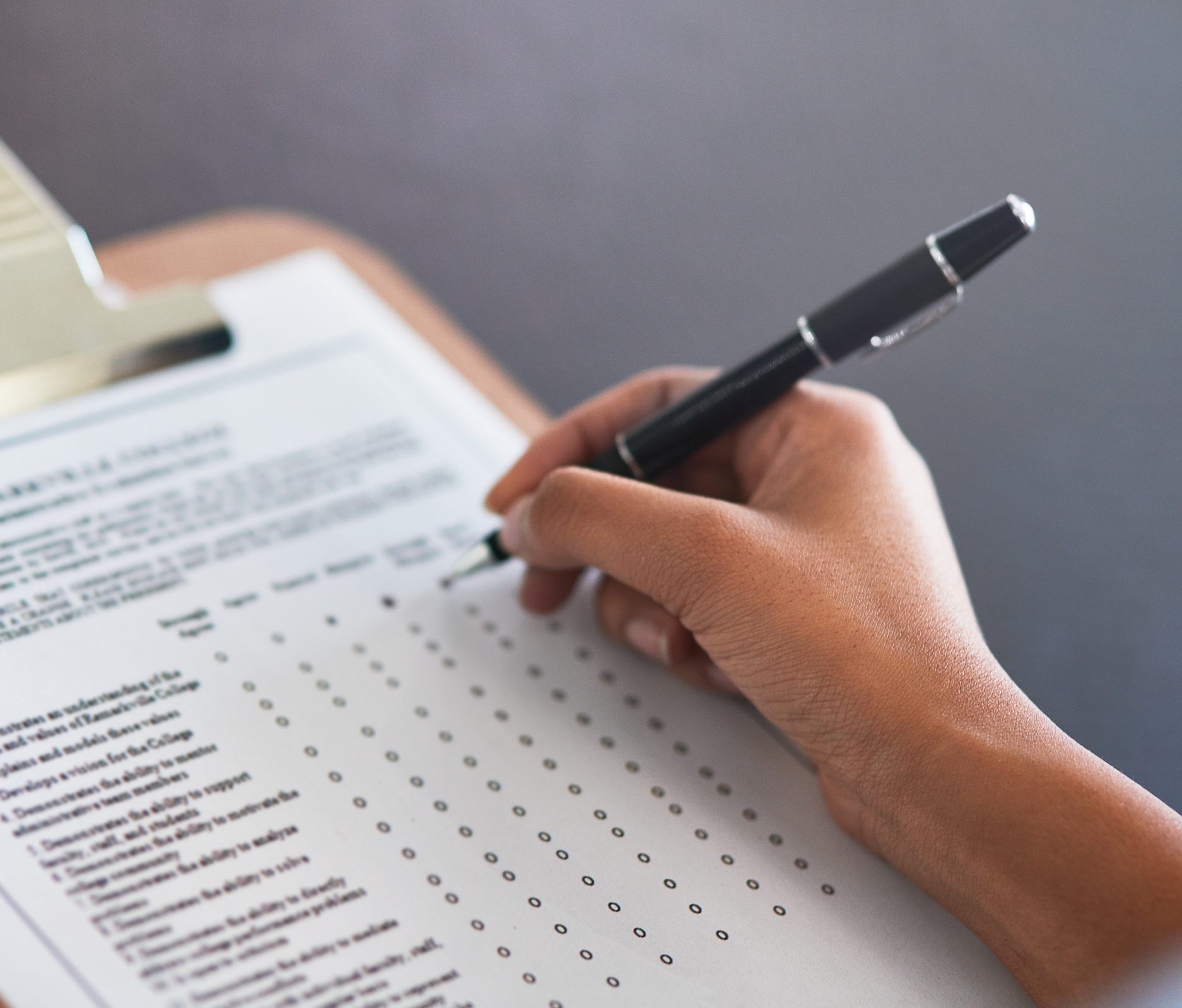 Image of a person's hand filling out a paper screening assessment