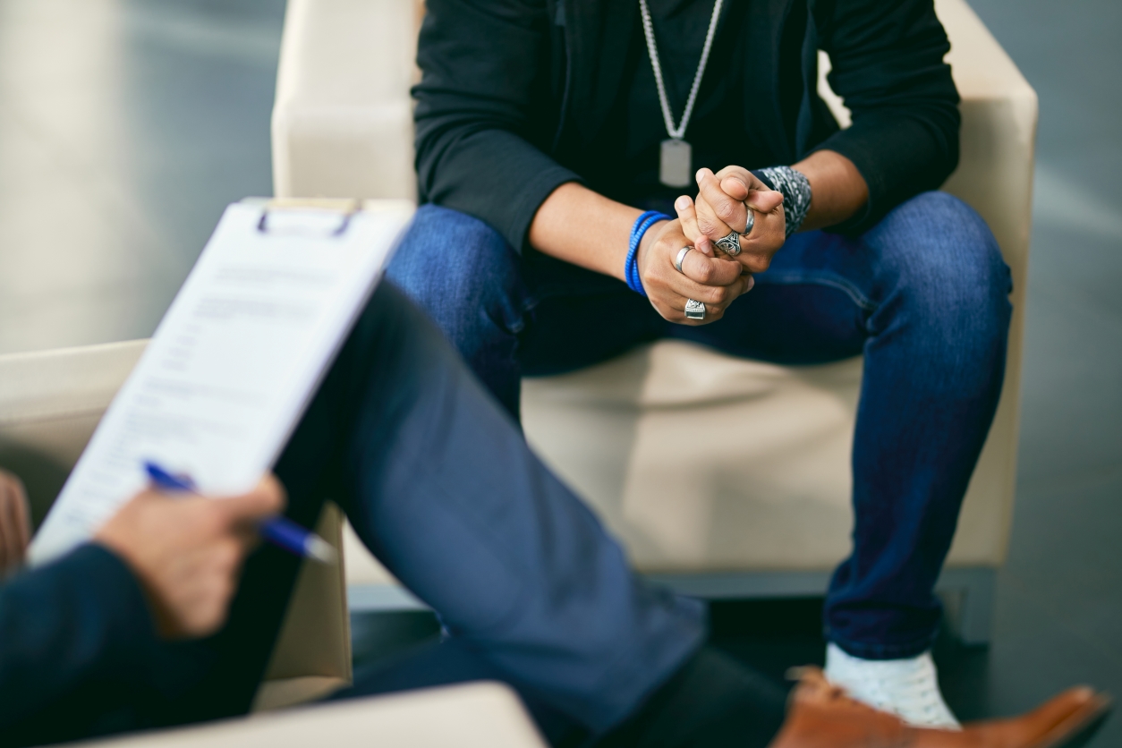 Photo of a person's hands while they sit in a counseling session